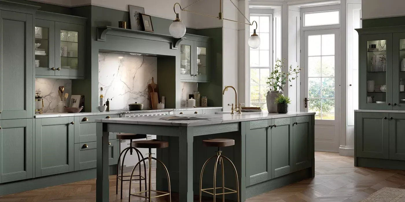 Sage green shaker kitchen with a marble island, brass taps and tall sash windows